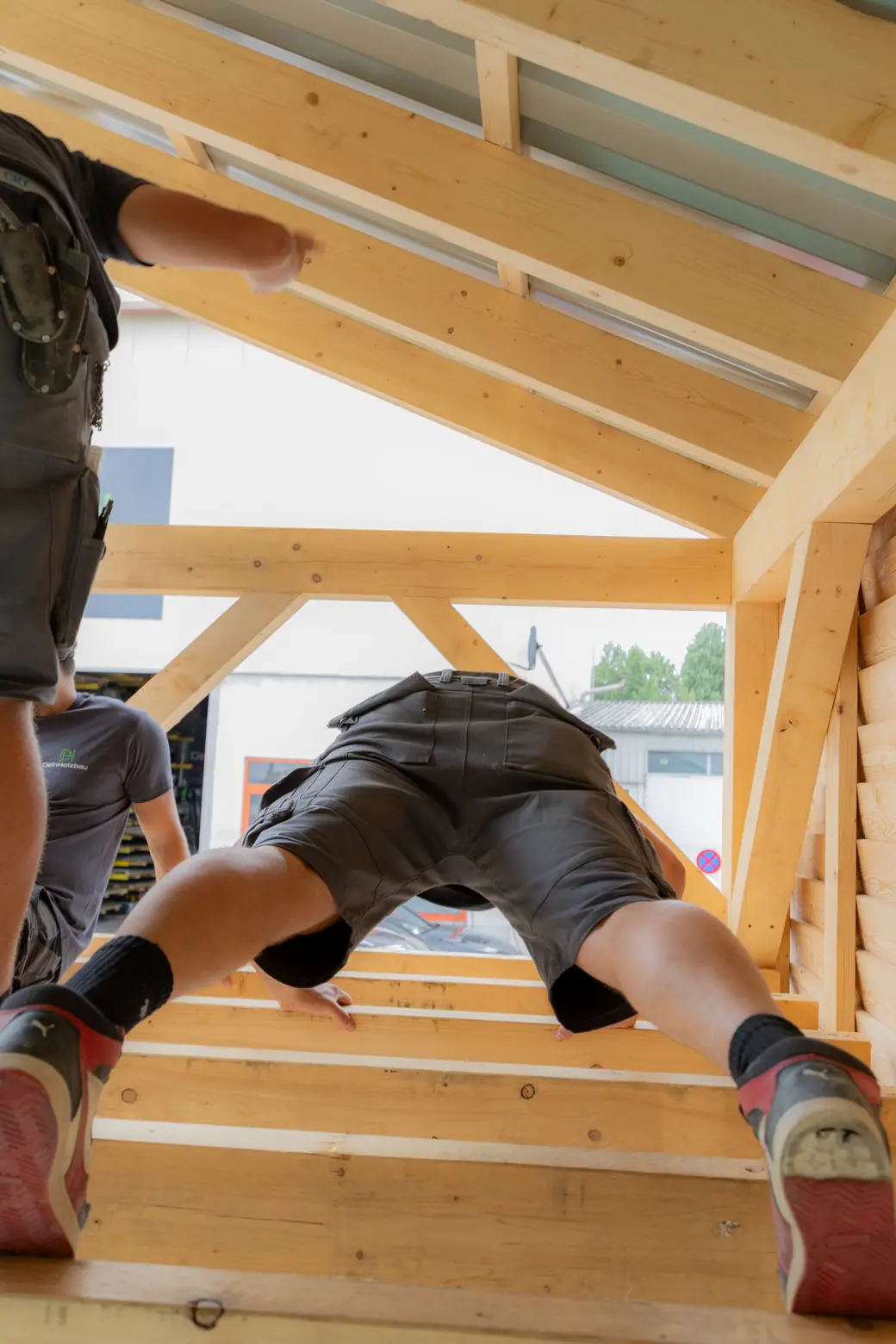 Zimmerer arbeitet auf einem Holztragwerk